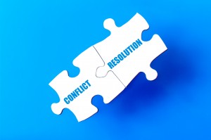 Connected puzzle pieces with words CONFLICT and RESOLUTION